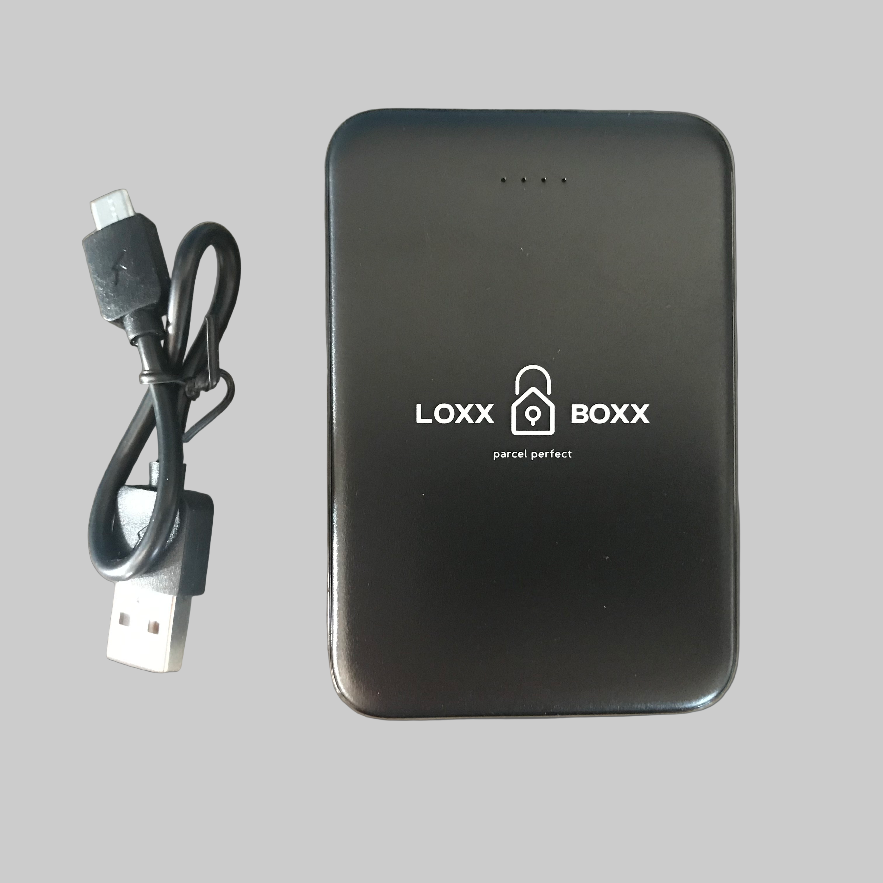 A black Loxx Boxx power bank with a capacity of 5000mAh, alongside a micro USB charging cable. The power bank has the brand name 'LOXX BOXX' written on the front.